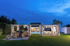 Uma área externa coberta com piscina, área de estar e pérgola.