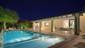 A swimming pool with lounge chairs and a covered patio area. - Villa Scarlet con Piscina Privata (Modica)