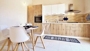 Une cuisine moderne avec des armoires en bois, un four encastré et une hotte de cuisine en acier inoxydable.