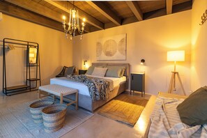 A cozy bedroom with a bed, bedside tables, a standing lamp, a chandelier, and a large abstract painting on the wall. - Villa Olive & Champagne con Piscina Privata (Ispica)