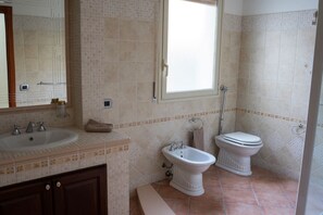 A bathroom with a sink, bidet, toilet, and a window. - Gemma di Mare SicilyMyHome (Pozzallo)