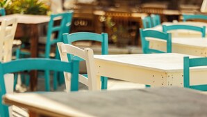 Un comedor con sillas y mesas turquesa y blancas, que sugiere un ambiente de comedor informal.