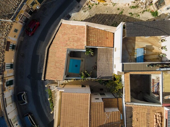 A rooftop with a swimming pool, a covered outdoor seating area, and a view of the street below. - Secret Riad Sicily My Home. (Noto)