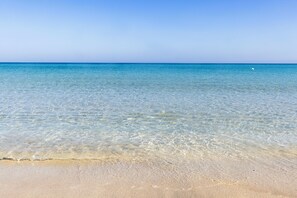 Una vista despejada de una playa con agua tranquila y una orilla arenosa.