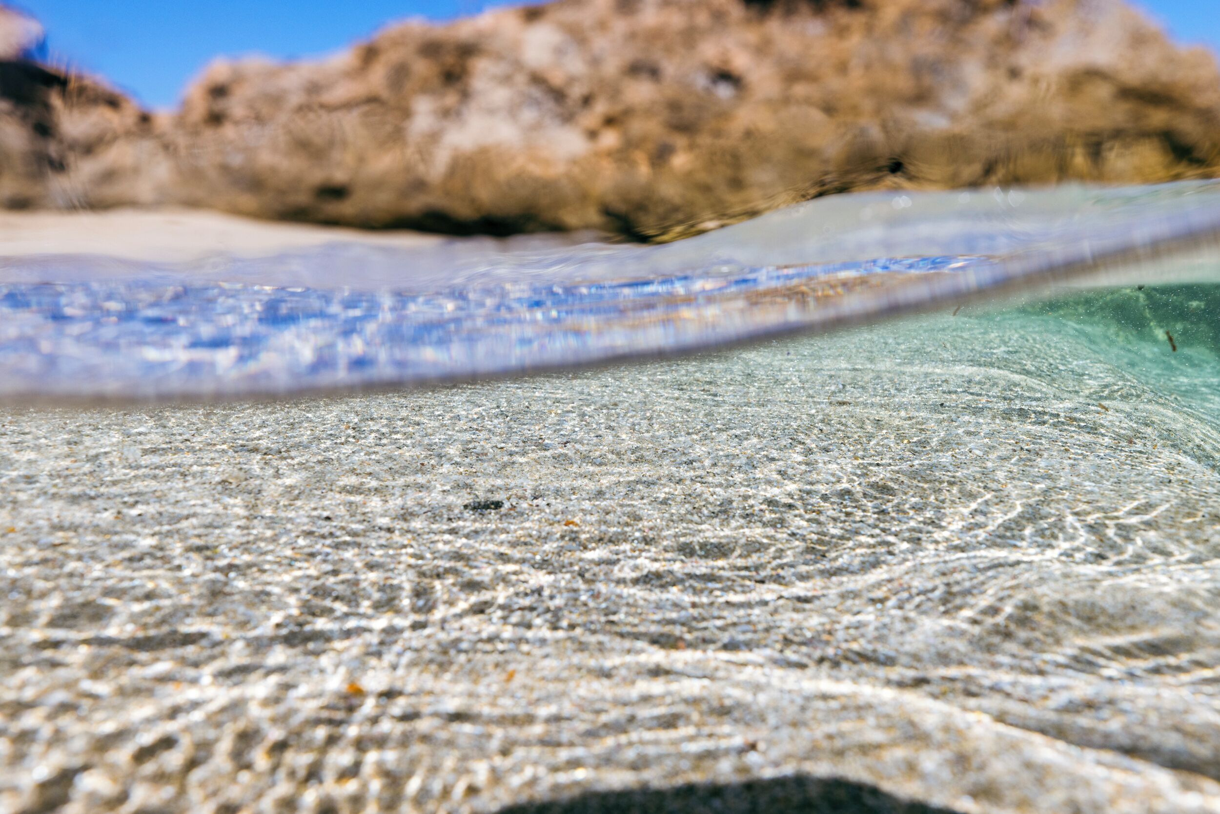 Primer plano de una playa arenosa con aguas cristalinas.