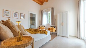 A bedroom with a bed, a chair, a lamp, a wardrobe, and a window with curtains. - Villa Calicanto con Jacuzzi Riscaldata (Modica)