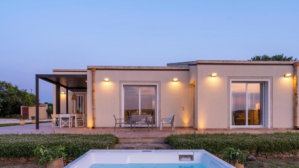 A modern house with a swimming pool, outdoor seating, and large windows. - Villa Calicanto con Jacuzzi Riscaldata (Modica)