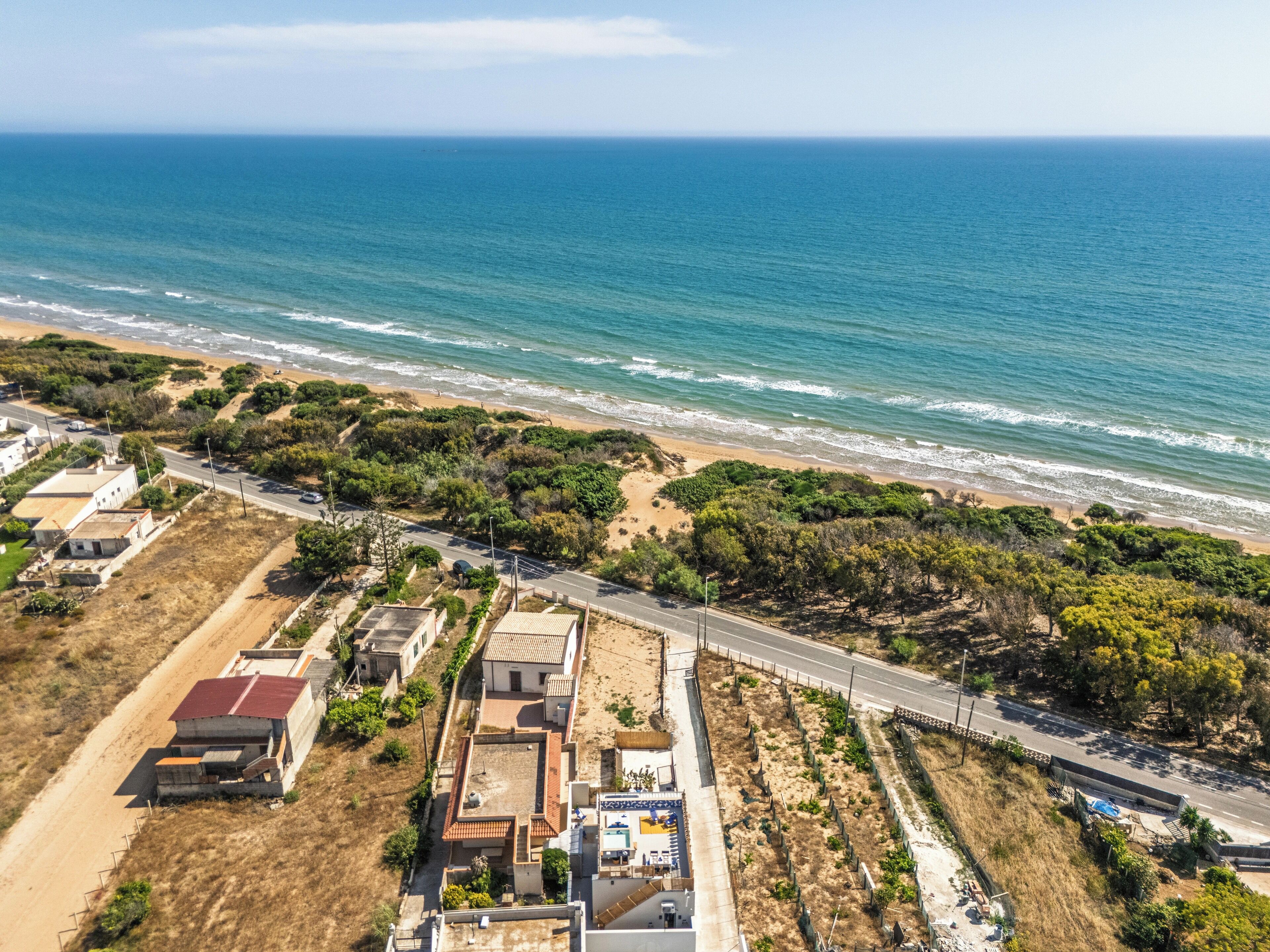 Vista aérea de una zona costera con una carretera, edificios y una playa.