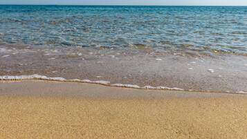 Una playa arenosa con olas suaves.
