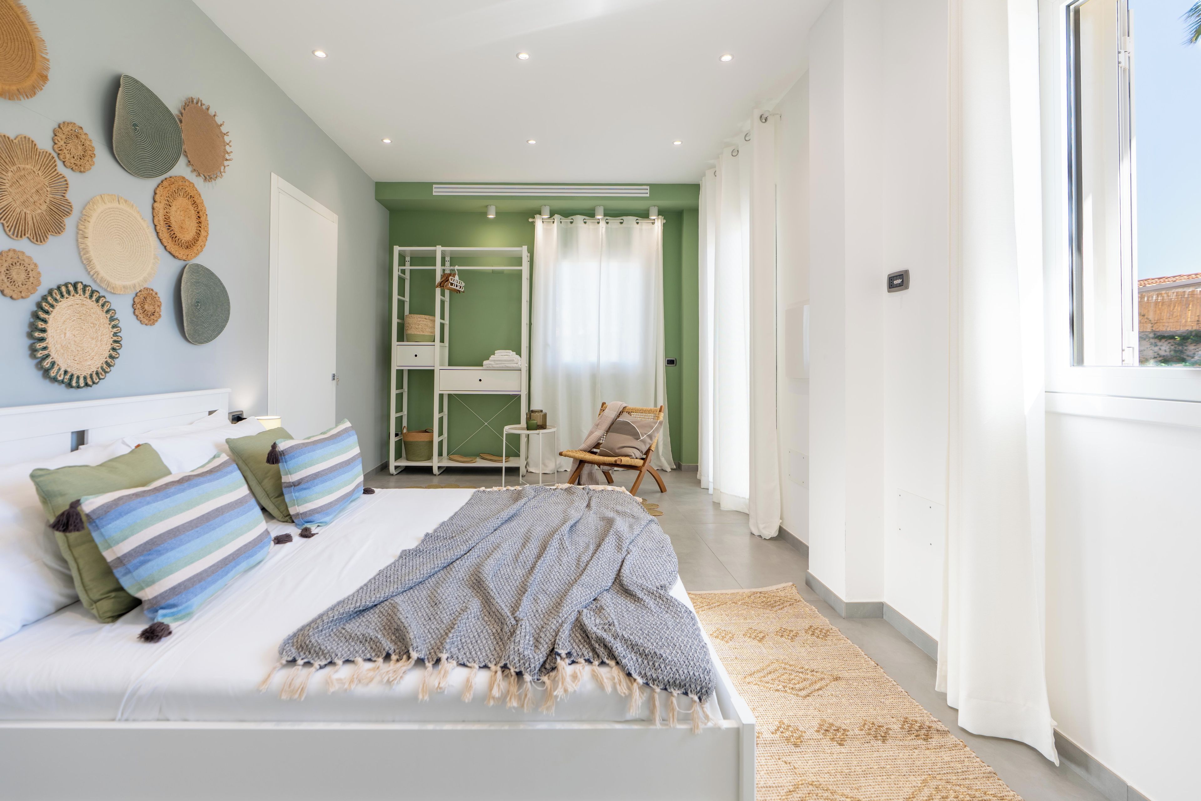 A bedroom with a bed, a wardrobe, a chair, and a window.