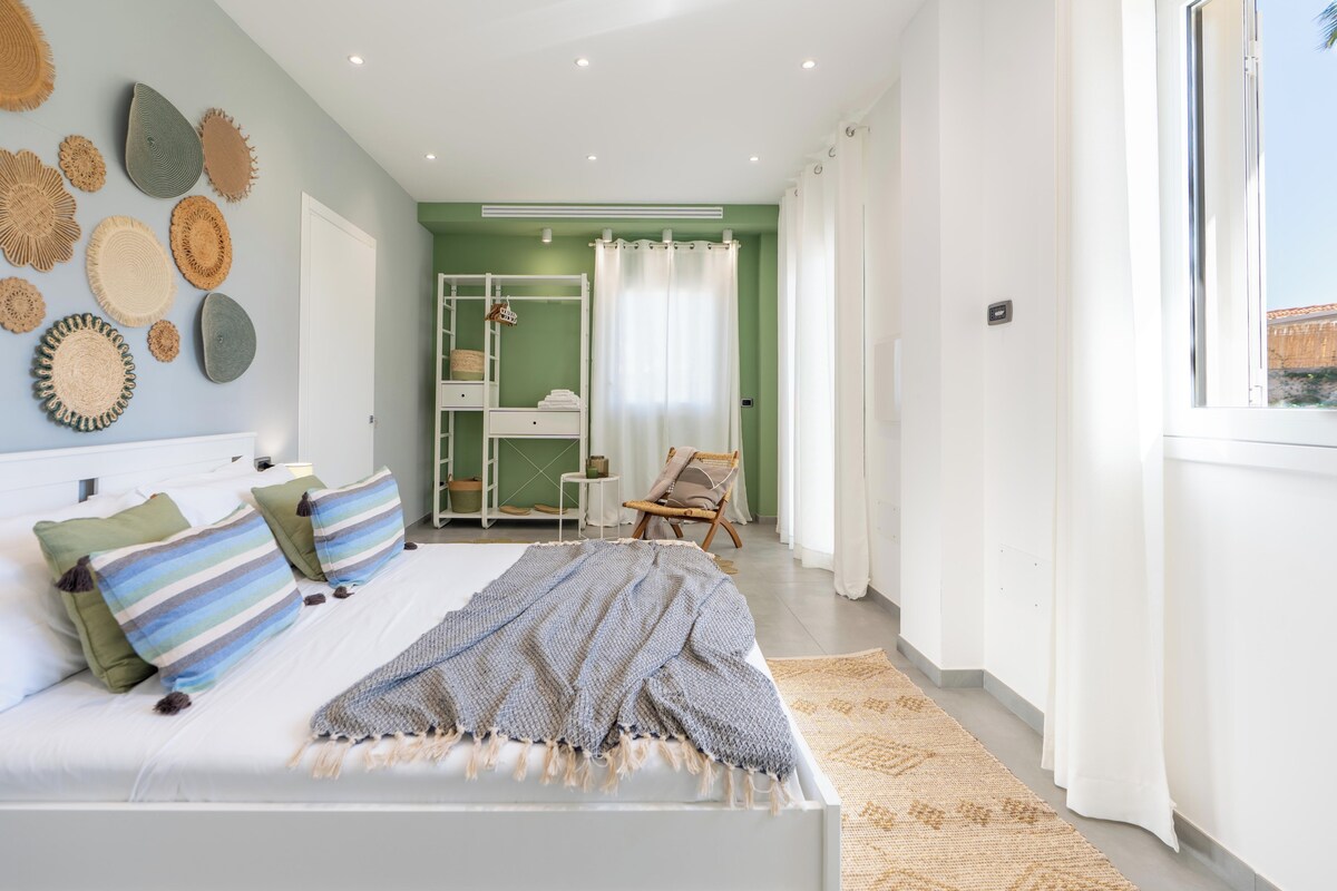Un dormitorio con cama, armario, silla y ventana.