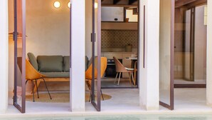Een modern interieur met een bank, stoelen, een eettafel en een keukenhoek.