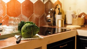 A kitchen with a hexagonal tile backsplash, a cutting board with a cabbage, a knife, and a glass jar. - Charming apartment in Rome a stone's throw from Villa Ada and Villa Borghese (Roma)