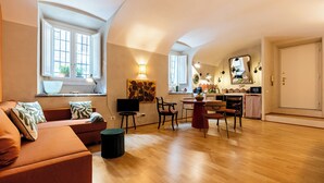 A modern living room with a sofa, TV, and dining area with chairs and a table. - Charming apartment in Rome a stone's throw from Villa Ada and Villa Borghese (Roma)