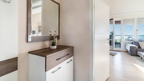 A modern bathroom with a large mirror, wooden vanity, and a potted plant. - Apartment “Auszeitwohnung Sasbachwalden - Pool” with Shared Terrace, Balcony, Sauna & Wi-Fi (Sasbachwalden)
