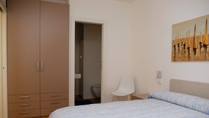 Ein Schlafzimmer mit einem Bett, einem Kleiderschrank, einem Sessel und einem Bild an der Wand.