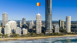 Un paisaje urbano costero con edificios altos, una bandera y una playa.