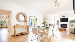 Een moderne woonkamer met een eethoek, een open haard en een televisie.