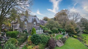 A large stone house with a well-maintained garden, a stone staircase, and a lawn. - The Old Rectory - 5 Bedroom Holiday Home - Llanedi (Swansea)