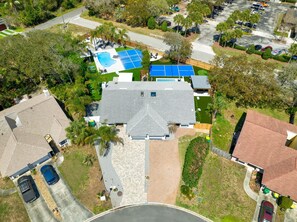 An aerial view of a residential property with a large house, a swimming pool, tennis courts, and a parking area. - 2 homes • 2 Heated Pools • 2 Courts • Sleeps 18 (Jacksonville Beach)