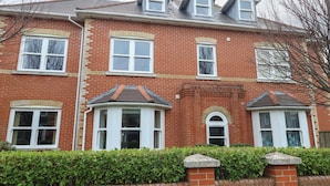 A red brick house with multiple windows and a small garden. - Harbour Reach 7 (Weymouth)