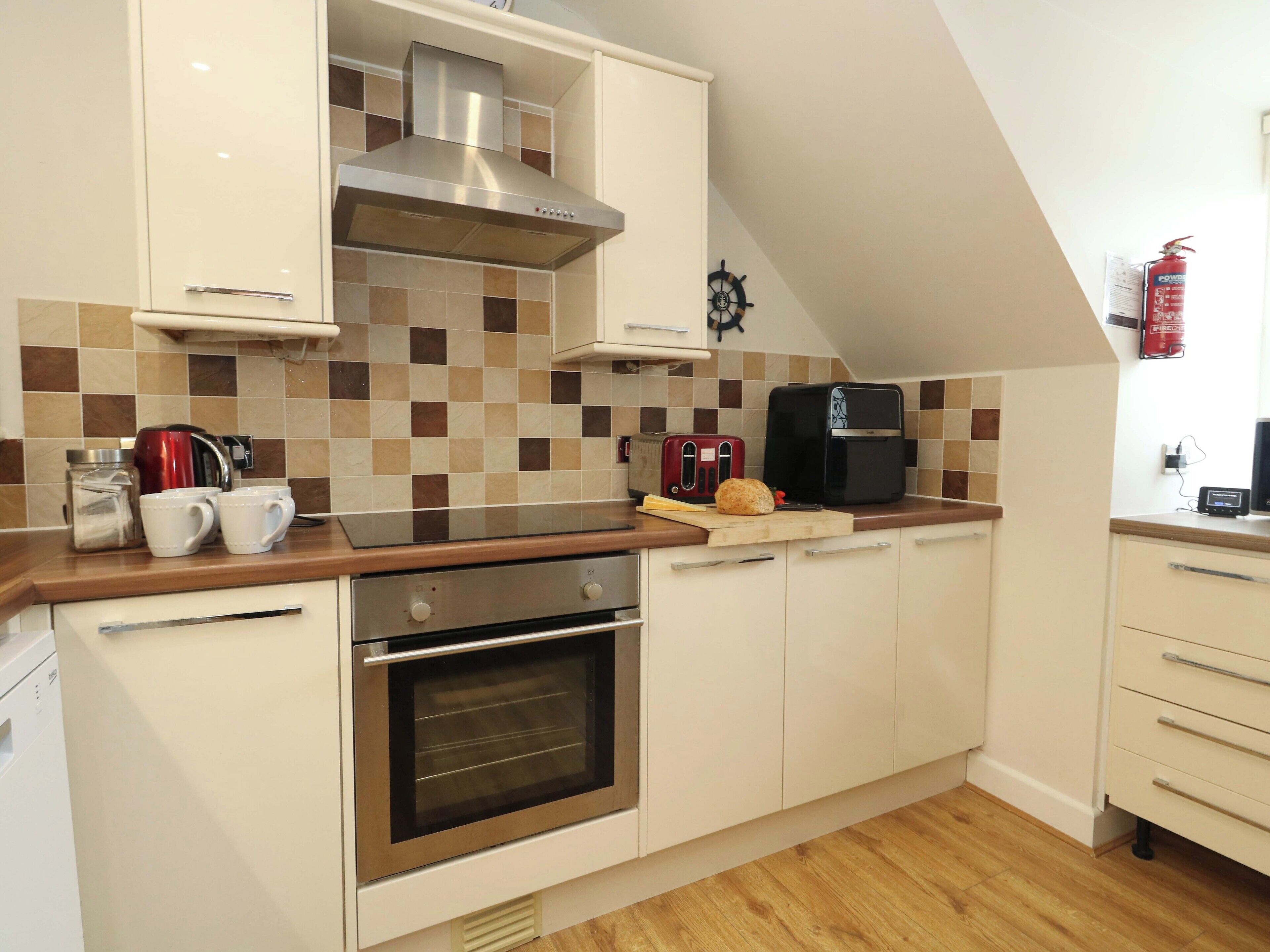 A modern kitchen with a built-in oven, a coffee maker, and a toaster.