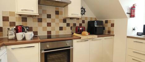 A modern kitchen with a built-in oven, a coffee maker, and a toaster.