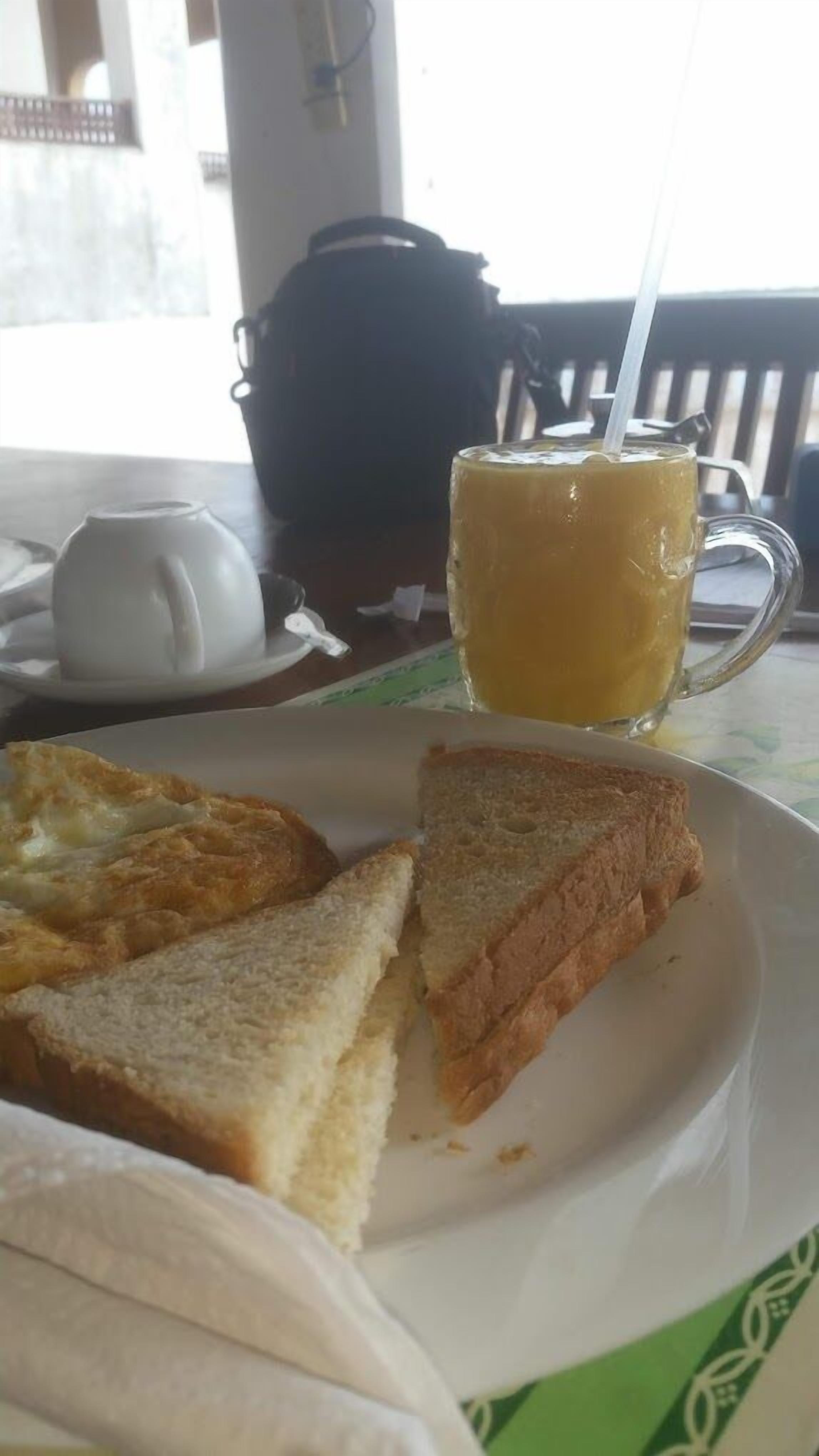 A table with a plate of toast and a glass of orange juice.