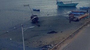 A coastal road with boats docked on the water and a pedestrian path alongside. - Stopover Guest House Lamu Town (Lamu)