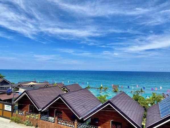 Un hotel costero con varias habitaciones tipo bungalow, una zona de piscina y vistas al océano.