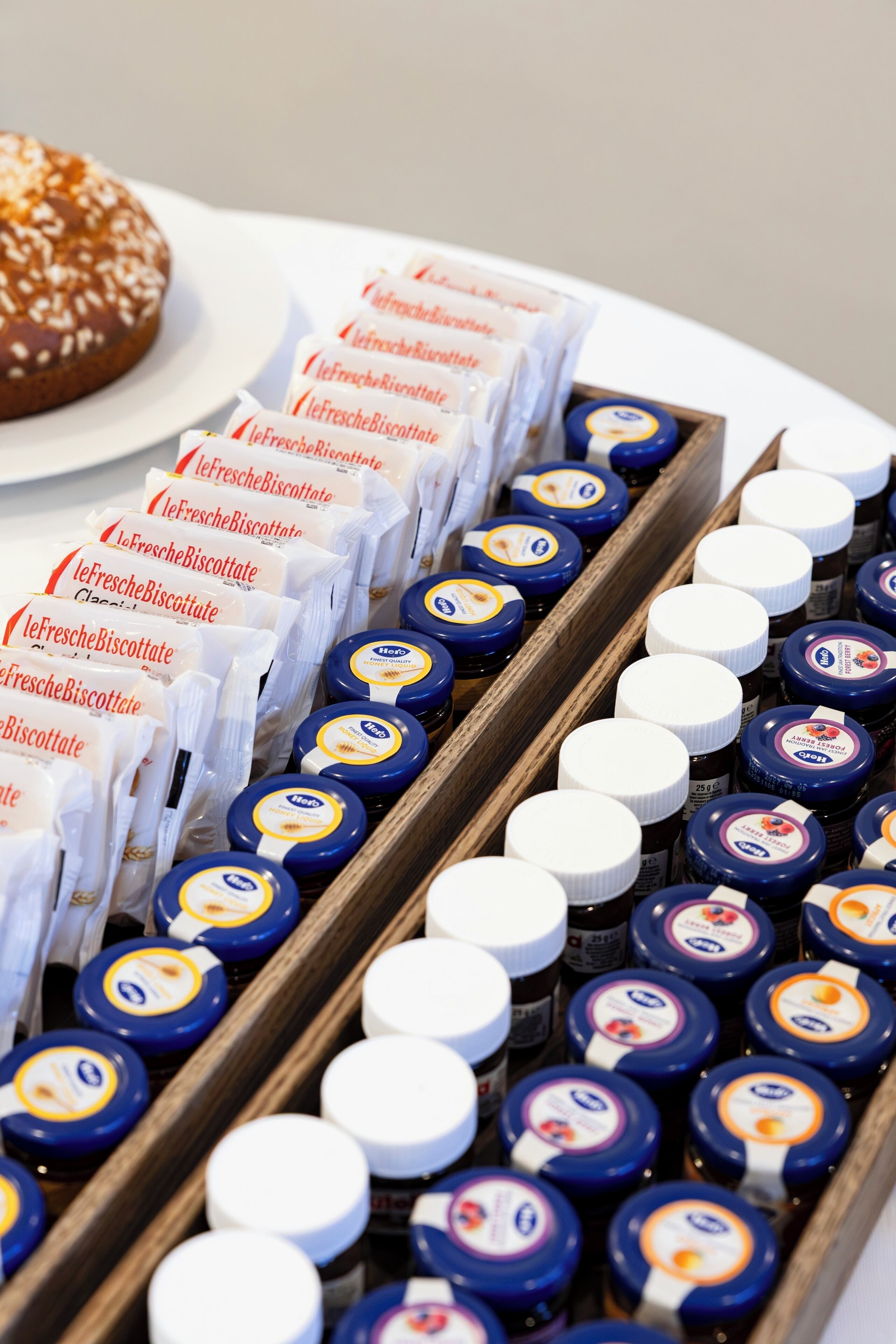 Een schaal met verpakte etenswaren, waaronder koekjes en potten, vermoedelijk te koop of om uit te stellen.