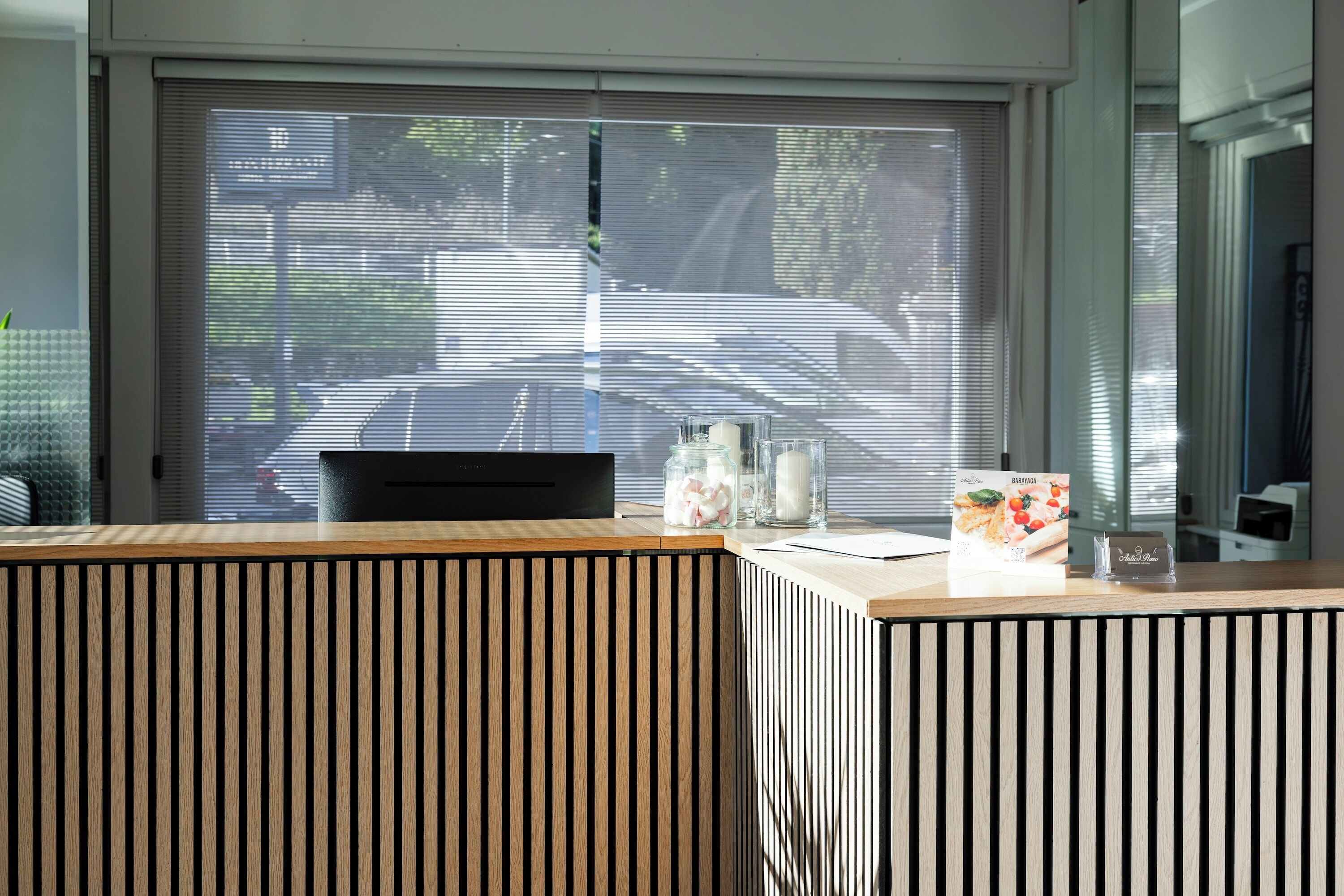 A reception desk with a view of a street through a window.