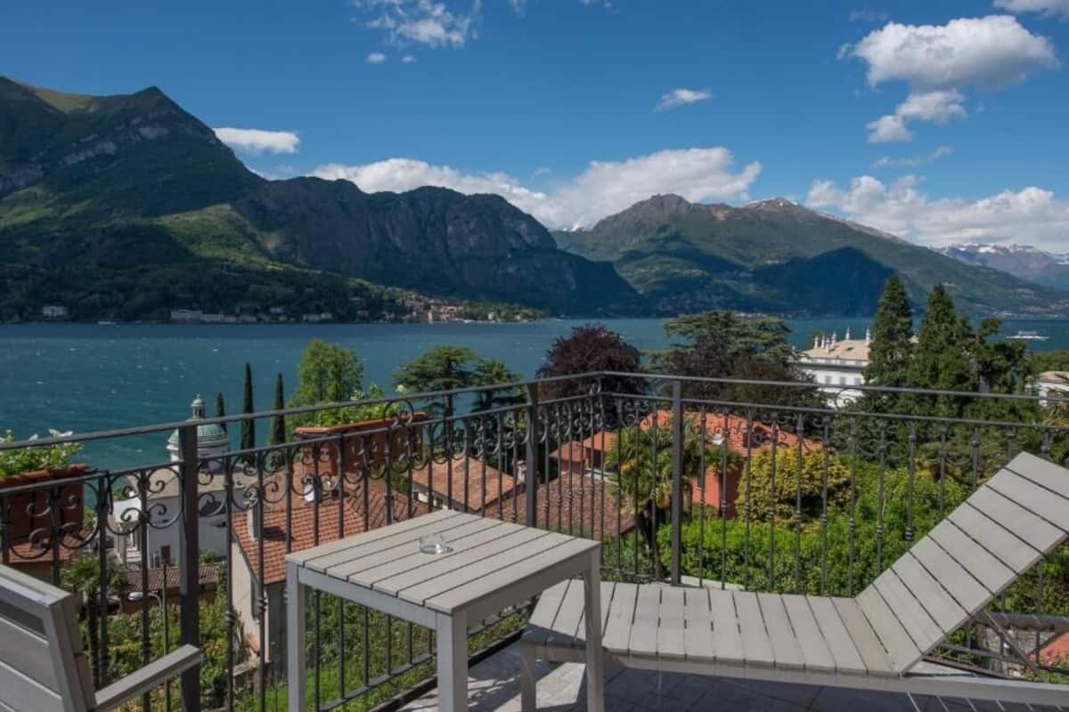 A balcony with a view of a lake and mountains.