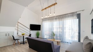 Un salon moderne avec un canapé, une table à manger et un téléviseur.