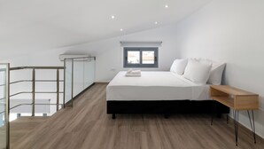 Une chambre à coucher avec un lit, une table de chevet, une fenêtre et un balcon.