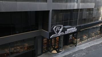 Un edificio moderno con fachada de vidrio, un logotipo destacado y un letrero que indica que es administrado por Nedeman.