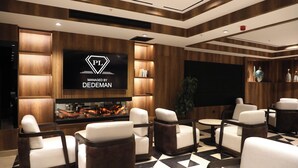 Un espace détente moderne doté d’un grand écran de télévision, de sièges confortables et d’un aquarium décoratif.