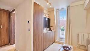 Una sala de estar moderna con un mueble de madera, un televisor de pantalla plana y vistas al exterior.