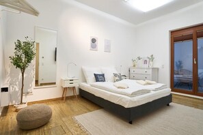 A modern bedroom with a bed, bedside tables, a mirror, and a potted plant. - Global Living Dresden Frauenkirche (Dresden)