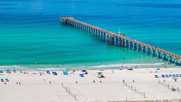 A pier extending into the ocean with a beach area at the end. - Beach House - Beachside Sunrise (Panama City Beach)