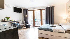 Een moderne hotelkamer met een bed, een bureau, een stoel en een balkon met uitzicht.