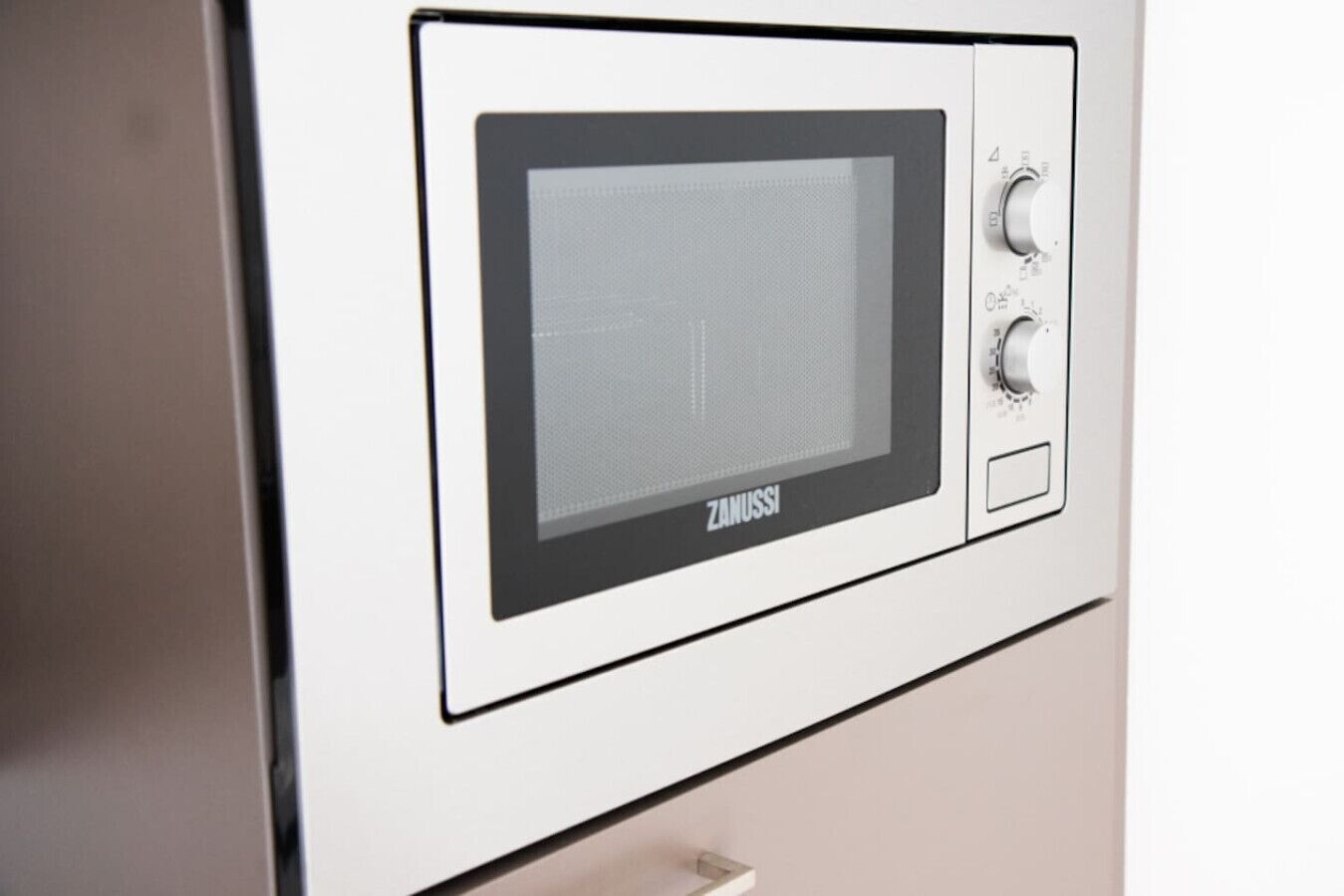 En Zanussi-mikrovågsugn med en kontrollpanel, en digital display och en strömknapp.