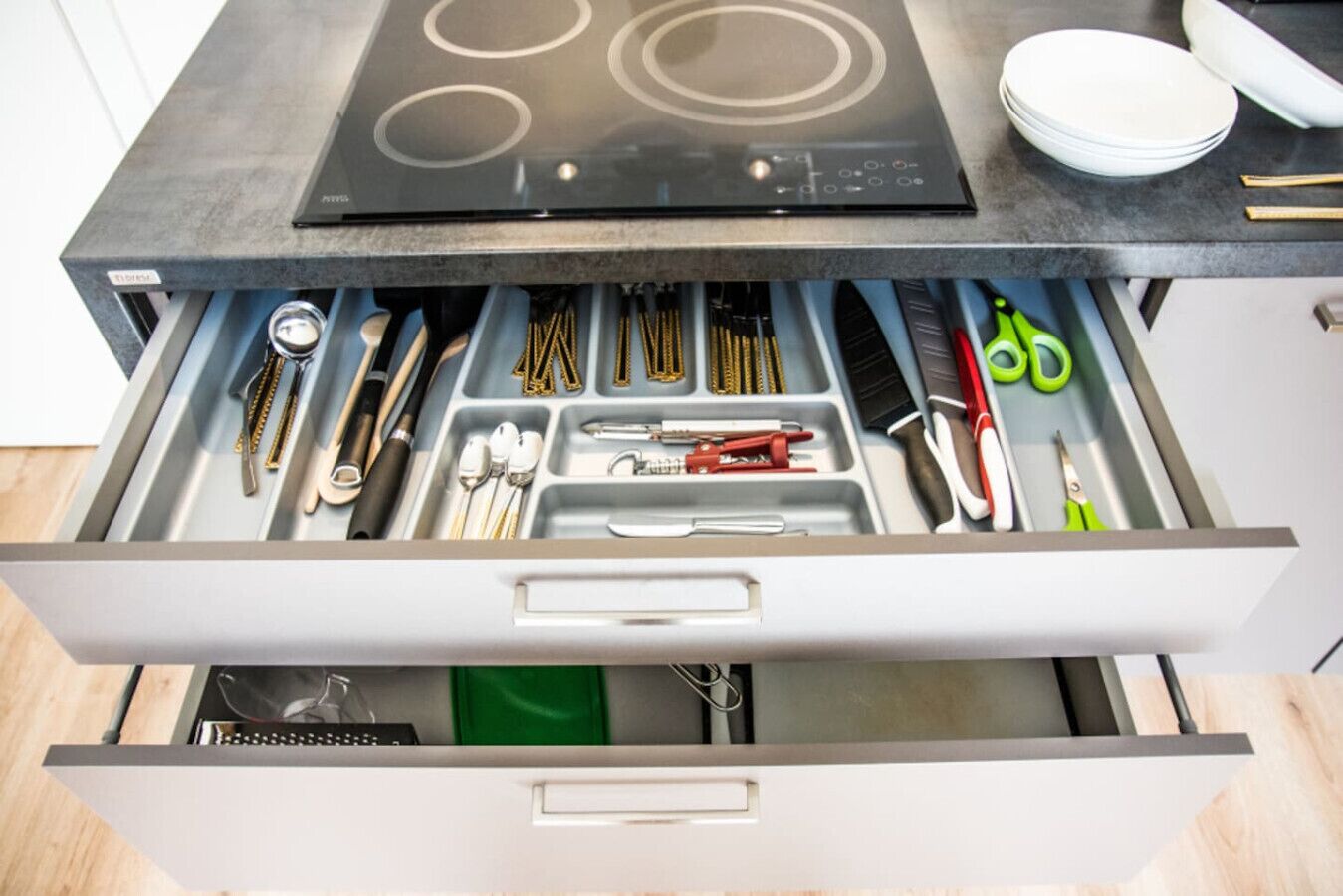 A kitchen drawer with utensils and tools.