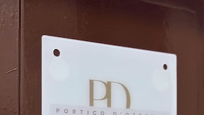 En skylt med texten ”PORTICO D’OTTAVIA” och en logotyp.