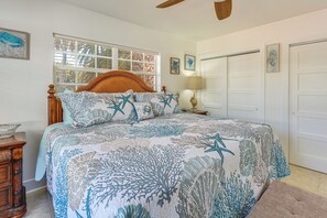 Un dormitorio con cama, cabecero de madera y mesita de noche con lámpara.