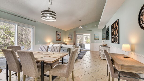 A dining area with a wooden table and chairs, a ceiling fan, and artwork on the walls. - 1 Mi From Beach, Private Yard + Community Pools (Panama City Beach)