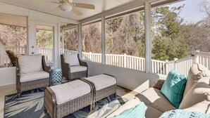A covered porch with wicker furniture, a ceiling fan, and a view of trees. - 1 Mi From Beach, Private Yard + Community Pools (Panama City Beach)