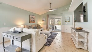 A living room with a sofa, a coffee table, and a TV stand. - 1 Mi From Beach, Private Yard + Community Pools (Panama City Beach)