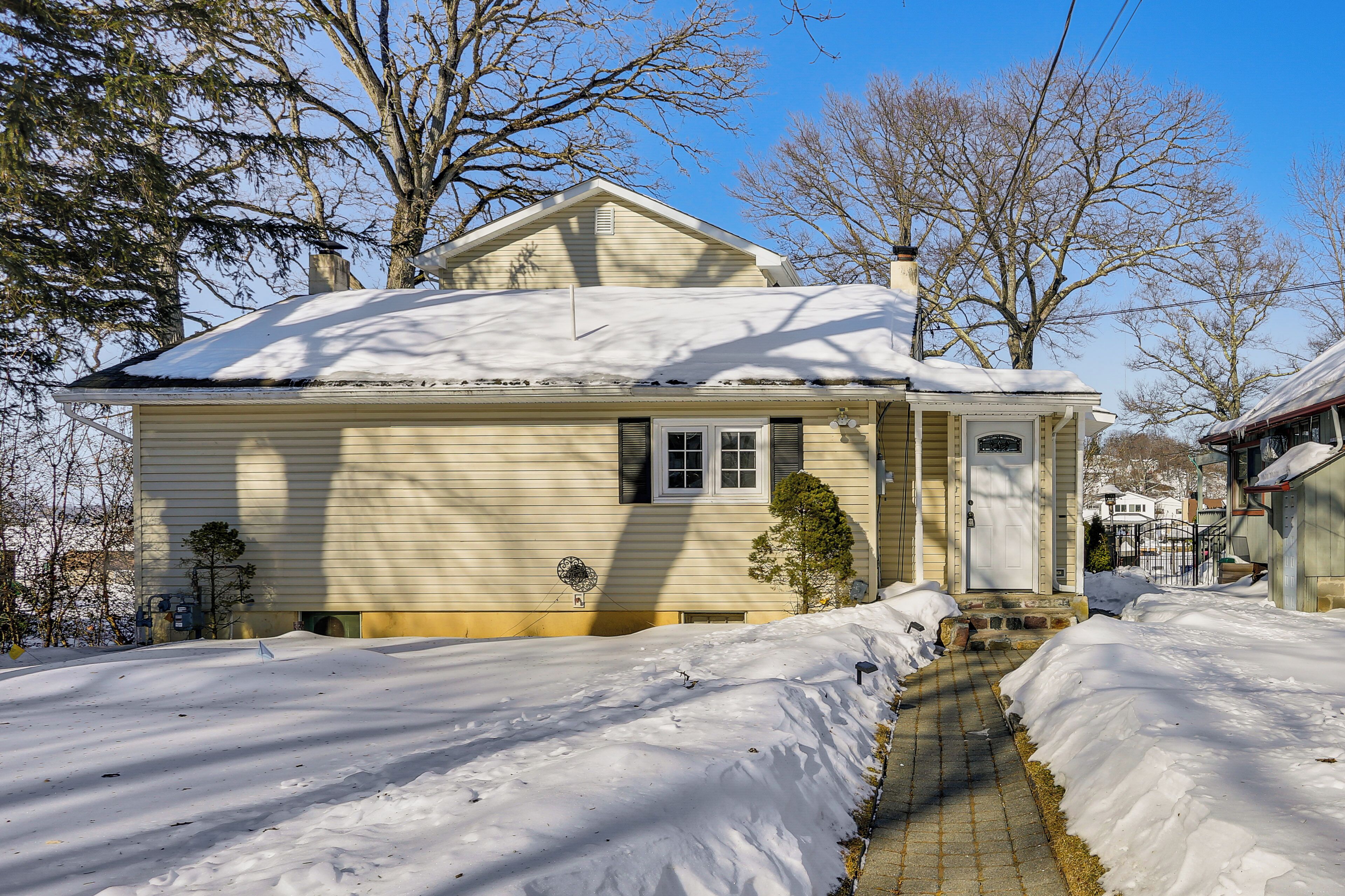 A two-story house with a snow-covered roof and a front porch.