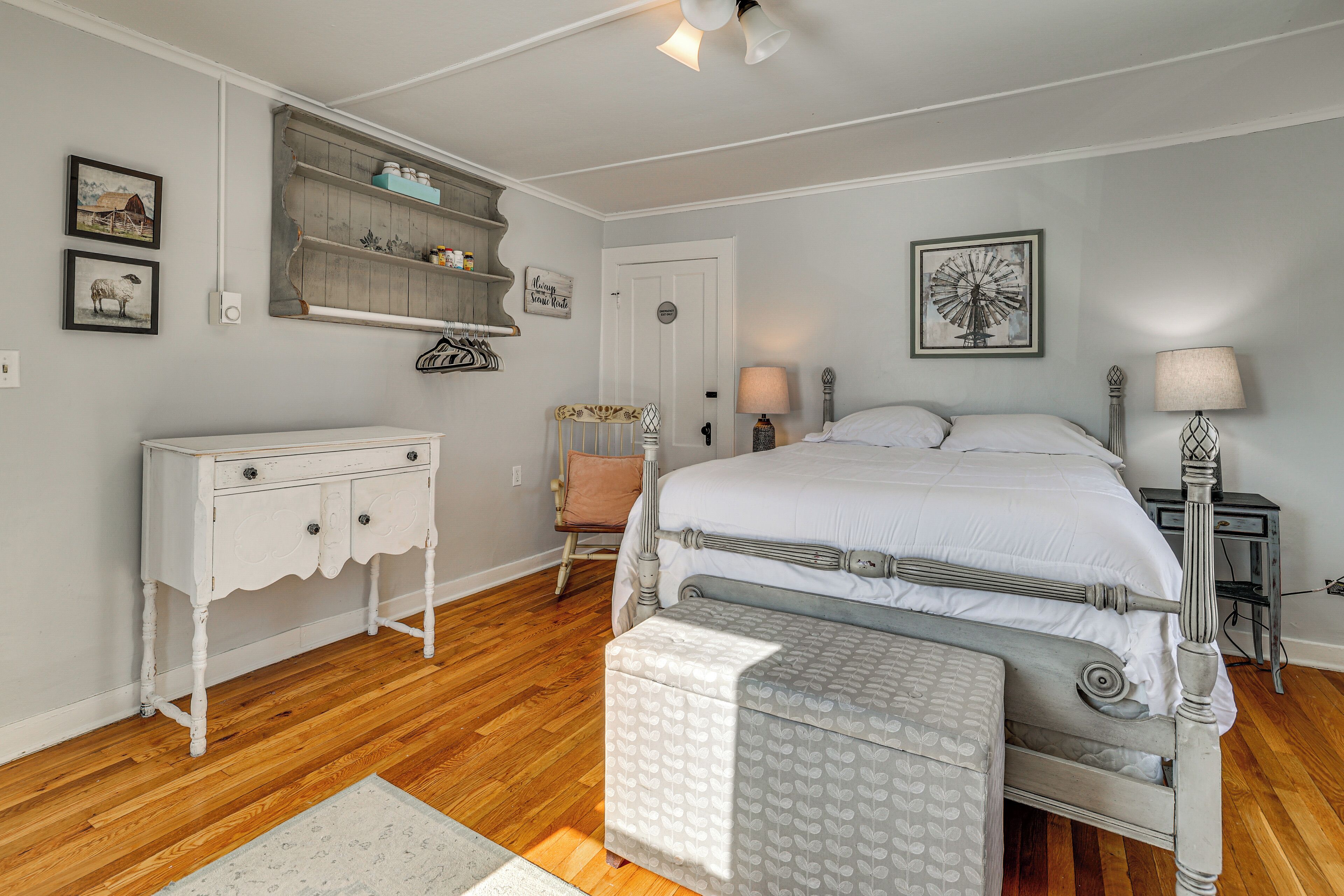 A bedroom with a bed, dresser, chair, and bedside tables.